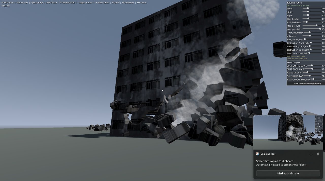 A grey, blocky building simulation mid-destruction, with debris and smoke, viewed from a slightly different angle. A 'Sn